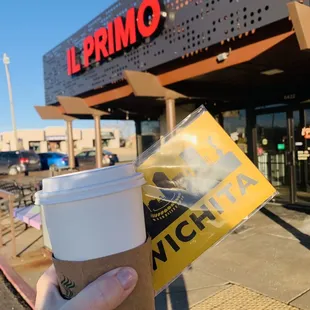 a hand holding a cup of coffee