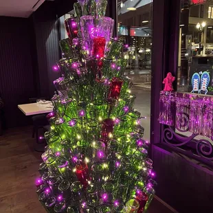 a lighted christmas tree in front of a window