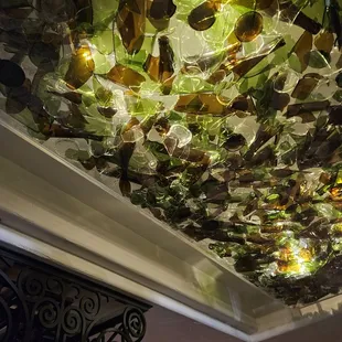 12/14/2023 - Drag'd to Dinner Holiday drag show! Il Solito's décor is pretty on point like this great broken wine bottle light fixture!