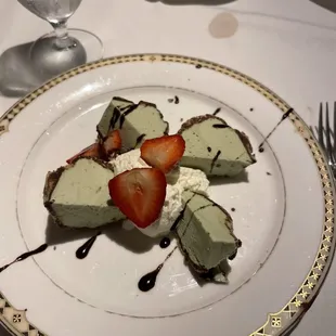 Pistachio ice cream covered in chocolate with strawberries