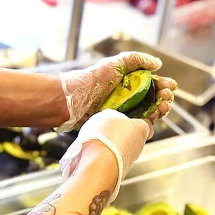 a person holding a piece of avocado