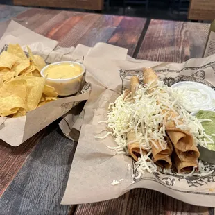 Small order of chips and queso and taquitos with a side of guac and sour cream