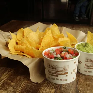 two cups of guacamole and chips