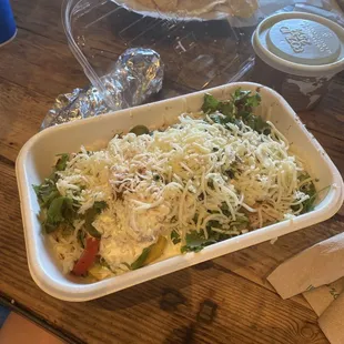 Burrito bowl, cheese, sour cream, primavera veggie, chicken and black beans.