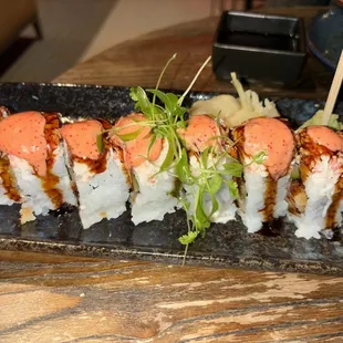 a plate of sushi with sauce and garnish