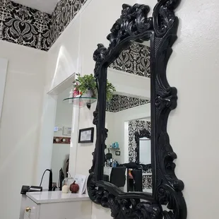 Beautiful accent pieces and mirrors are clean, crisp, and match the lovely wallpaper.