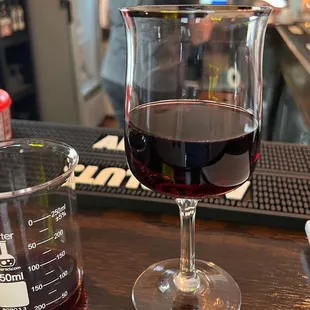 a glass of red wine and a beaker