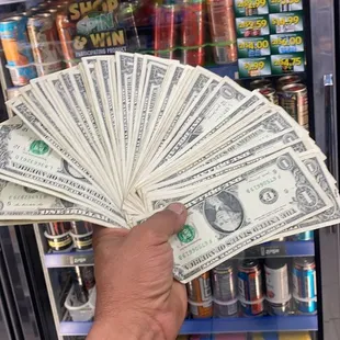 a hand holding a fan of money