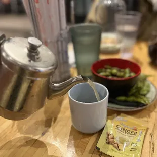 a tea pot pouring milk into a cup