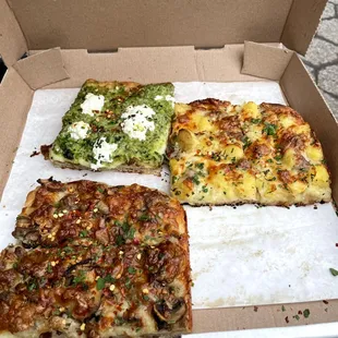 a pizza in a box with four different toppings