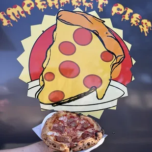 Spanish Charcuterie Pizza in front of the logo created by the owner&apos;s kid.