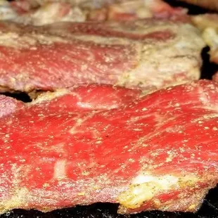 steaks being cooked on a grill