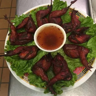 a plate of chicken wings on lettuce