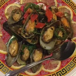 a plate of mussels and lemon slices