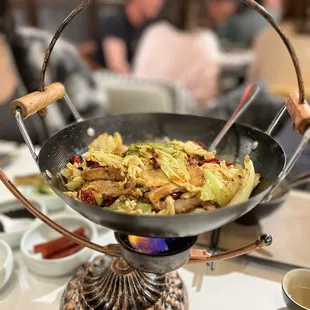 a wok of food on a table