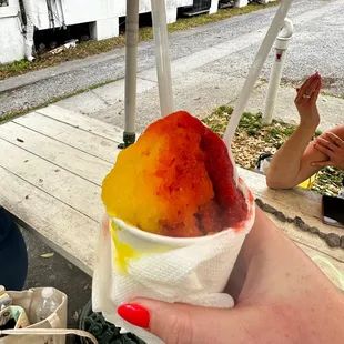 a hand holding a cup of ice cream