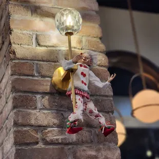 a statue of a clown on a brick wall