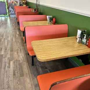 a row of tables with orange benches