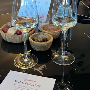 three wine glasses and a menu on a table