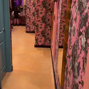 a hallway with pink wallpaper