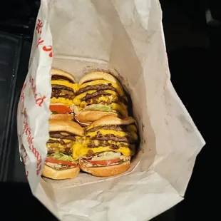Inn n out burgers tacked inside a paper bag tightly. So nasty, how many employees hands took to get this filthy job done??