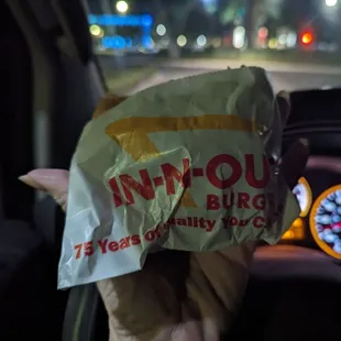 ows a hand holding a bag of food