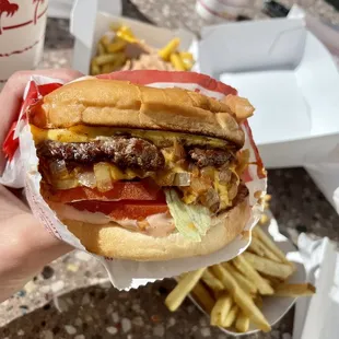 ows a hand holding a hamburger