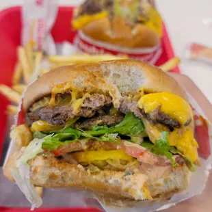 ows a hand holding a hamburger