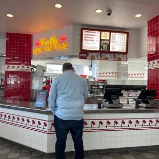 ows a man standing at a counter