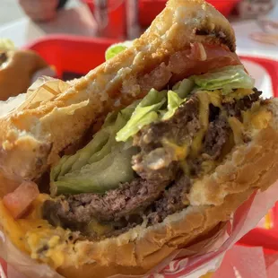 ows a hand holding a hamburger