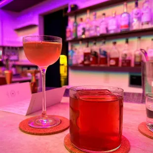 two glasses of alcohol on a bar counter