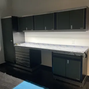 a work area with cabinets and a refrigerator