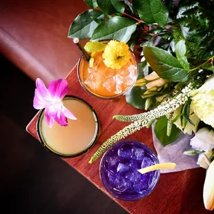 a bouquet of flowers and two cocktails