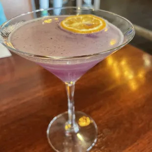 a purple drink with a slice of lemon