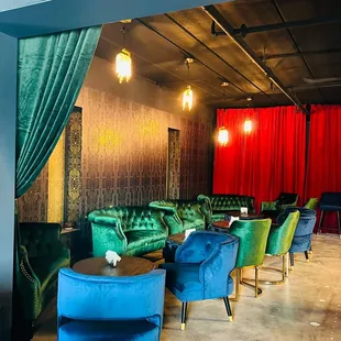 a green velvet couch and blue velvet chairs