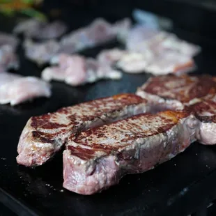 steaks being cooked on a grill