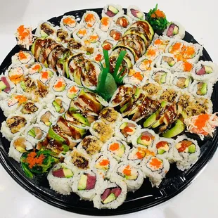 a platter of sushi and vegetables