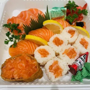 a tray of sushi and vegetables