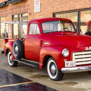 a red truck parked in front of a store