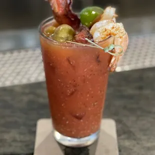 a bloody drink with shrimp and bacon