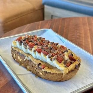 HEALTHY BOII - thick toasted multigrain. peanut butter base, sliced banana, goji berries, cacao nibs, cinnamon, honey.