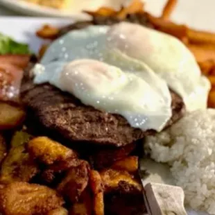 a plate of food with rice, meat, and vegetables