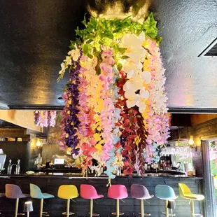a bar with a bunch of flowers hanging from the ceiling
