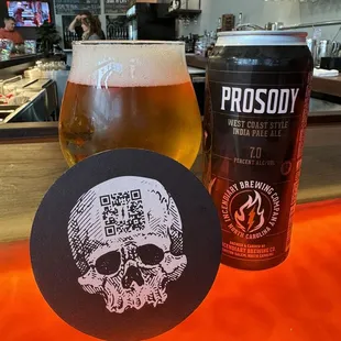 a glass of beer and a skull coaster