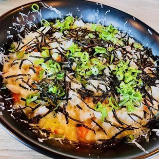 Abalone risotto with Pecorino Romano cheese, topped with shaved gim (dried seaweed) and green onion