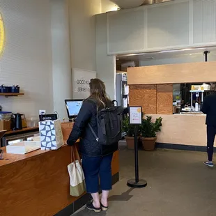 a woman standing at a counter in a coffee shop