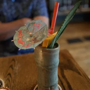 a drink in a cup with a paper umbrella