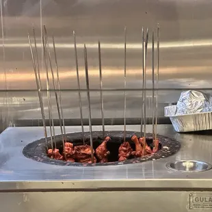 skewers of meat being cooked in a fryer