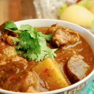 a bowl of curry with meat and potatoes