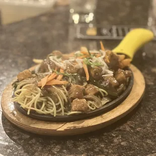 a plate of noodles and meat